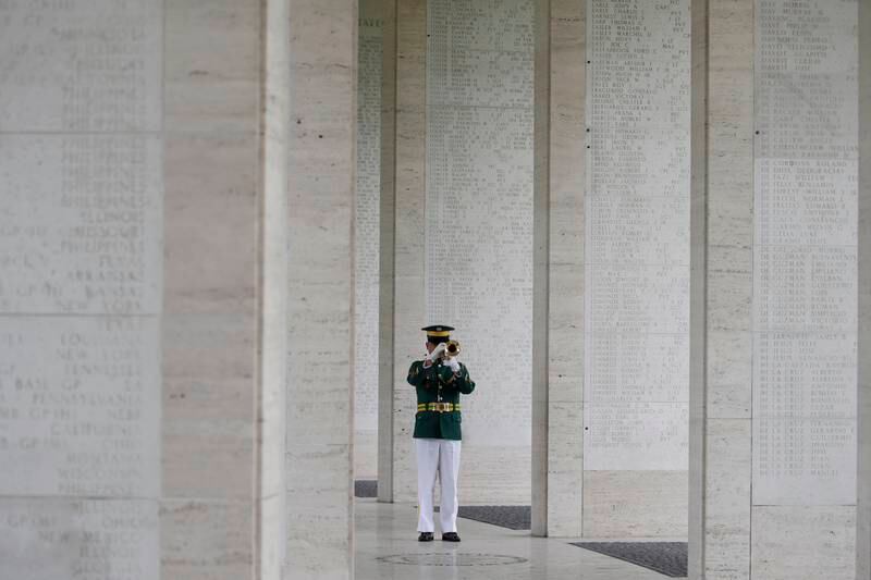 A Filipino soldier plays 'Taps' on his trumpet along a hall of walls with names of 'Missing in Action' soldiers during a Veterans Day ceremony at the Manila American Cemetery and Memorial in Taguig, Philippines.  EPA
