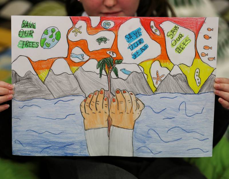 A pupil holds a poster at St Convals Primary School in Glasgow while learning about climate change ahead of Cop26. About 25,000 people are expected to attend the summit.  Reuters