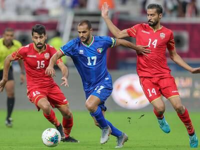 Kuwaiti striker Bader Al Mutawa slides past two Bahrain players in the Arabian Gulf Cup on December 2, 2019. Karim Jafaar / AFP