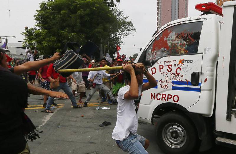 A man hits a Philippine National Police van with a stick after it rammed anti-US protesters outside the American embassy in Manila. Bullit Marquez / AP Photo