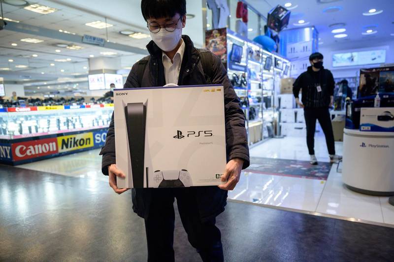 In a photo taken on November 12, 2020, a customer walks away after purchasing the new Sony Playstation PS5 in Seoul after Sony launched the new console in select markets around the world.  / AFP / Ed JONES
