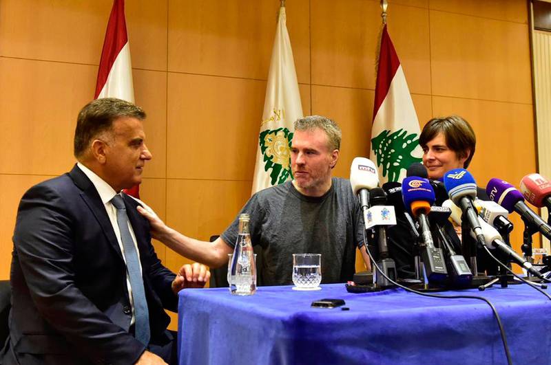 This handout photo by the Lebanese General Security Directorate, shows Maj. Gen. Abbas Ibrahim, left, Lebanon's General Security Chief, speaks with Canadian citizen Kristian Lee Baxter, center, who was released from Syrian prisons to Lebanon, during a press conference in Beirut, Lebanon, Friday, Aug 9, 2019. Baxter held in Syrian prisons since last year and freed after Lebanese mediation said Friday he had no idea if anyone knew he was still alive.  The Lebanese general who mediated his release said Baxter was heading home. It was not clear when Baxter was released from Syria. (The Lebanese General Security Directorate via AP)