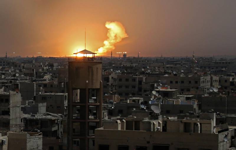 Flames erupt on the horizon following a reported rocket attack in the rebel-held enclave of Eastern Ghouta on the outskirts of the Syrian capital Damascus. Ammar Suleiman / AFP