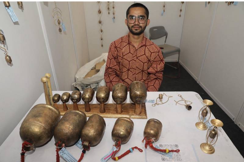 Anas Lohar sits with his Kutch Bells creations at a craft exhibition. Photo: Anas Lohar