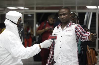 A Nigerian health official uses a thermometer to screen a person at the arrival hall of the international airport in Lagos, Nigeria. Etihad Airways is closely monitoring the Ebola outbreak in West Africa. Sunday Alamba / AP Photo 