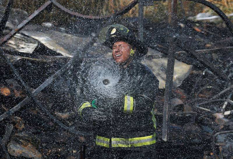 A firefighter puts out the embers of a fire near the Central de Abasto, the main food distribution centre in Mexico City. AP Photo