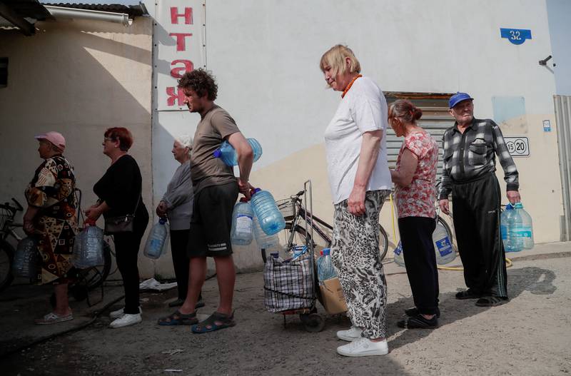 Residents queue to fetch water in the town of Rubizhne, in Ukraine's Luhansk enclave. Reuters