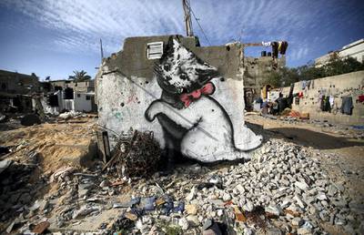 epa04640744 A graffiti mural of a kitten, presumably painted by British street artist Banksy, on the wall of the destroyed house of the Al Shimbari family which was damaged during the 2014 conflict between Israel and Hamas, in Beit hanun town in the northern Gaza Strip, 27 February 2015.  EPA/MOHAMMED SABER *** Local Caption *** 51820508