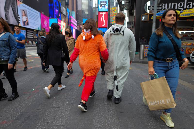 People dressed in costumes walk through Times Square in Manhattan, New York. Reuters