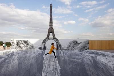 epaselect epa09231845 A woman poses in a trompe-l'oeil art installation by French photographer and artist Jean Rene, known as JR, set up at the Trocadero in front of the Eiffel Tower in Paris, France, 27 May 2021.  EPA-EFE/YOAN VALAT