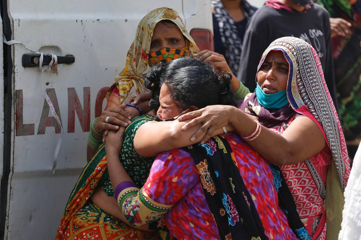 Relatives of a patient who died of COVID-19, mourn outside a dedicated COVID-19 government hospital in Ahmedabad, India, Saturday, April 17, 2021. The global death toll from the coronavirus topped a staggering 3 million people Saturday amid repeated setbacks in the worldwide vaccination campaign and a deepening crisis in places such as Brazil, India and France. (AP Photo/Ajit Solanki)