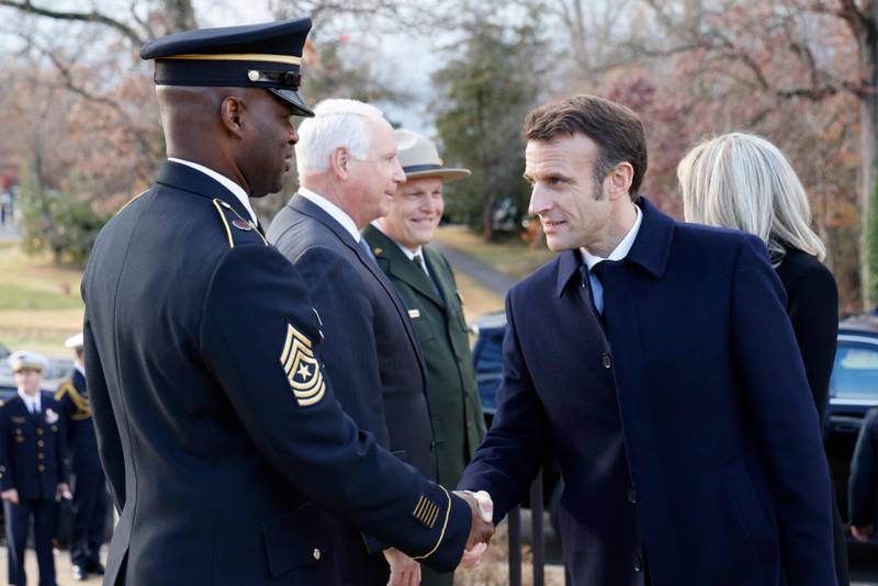 Mr Macron is greeted by a US serviceman at Arlington National Cemetery.  AFP