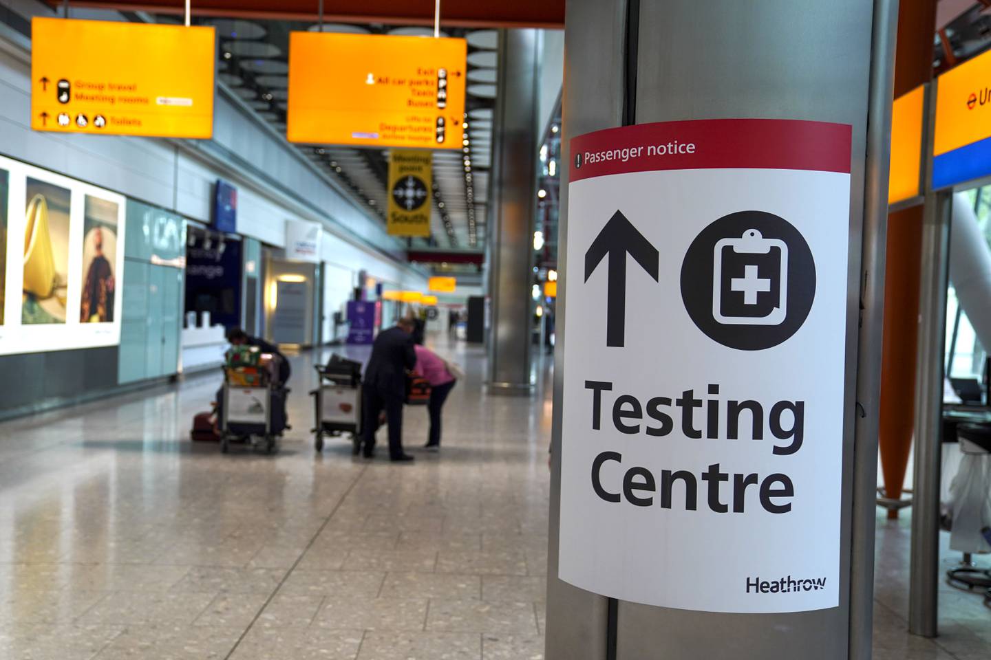 A sign directs passengers to a testing centre at Heathrow Airport in London. PA