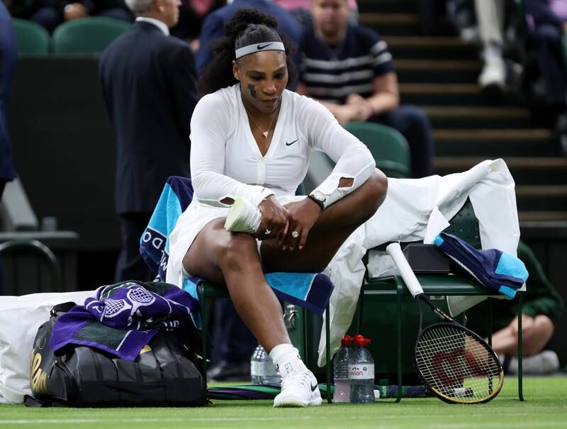 Serena Williams holds her ankle in a change over against Harmony Tan. Getty Images