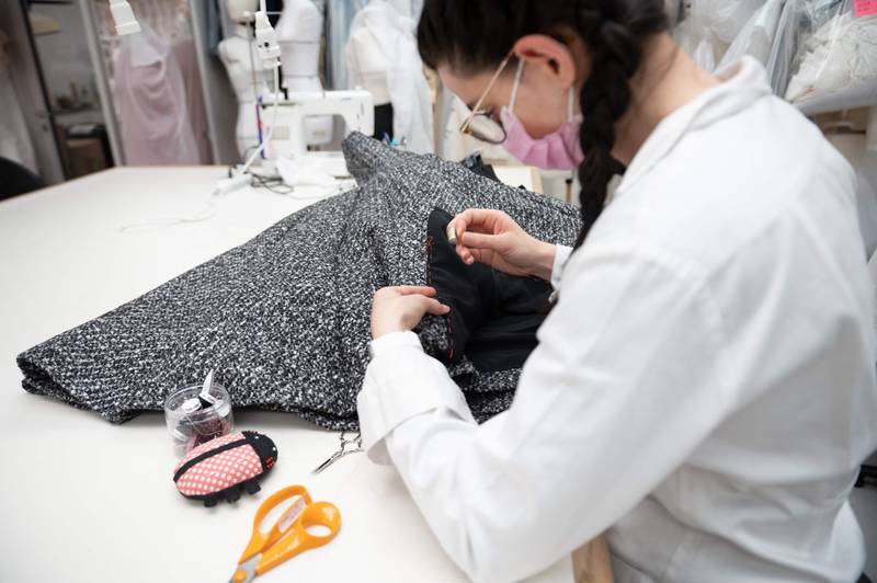 An employee works on the haute couture collection at the Christian Dior headquarters in Paris on July 3, 2021.
