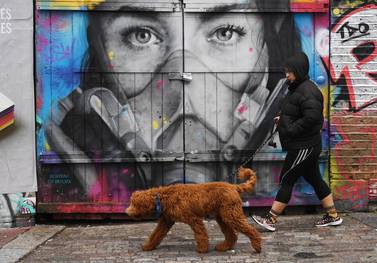 A walker passes a Covid themed grafitti in the Tower Hamlet area of London, Britain. UK finance minister Rishi Sunak’s original furlough programme will be replaced by a less-generous Job Support Scheme on November 1. EPA
