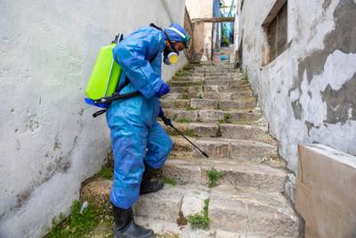 A municipal worker carries out disinfection at a street in downtown Amman, Jordan, 22 March 2020. EPA
