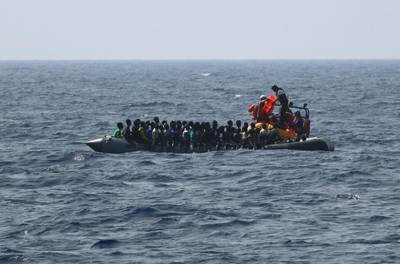 In this photo released Friday, Aug. 9, 2019, the SOS Mediterranee rescue team distributes life-jackets to men, women and children on a rubber boat in distress off Libya, before taking them onboard the Ocean Viking rescue ship. Italian Interior Minister Matteo Salvini, who has triggered a government crisis in Italy, said he is preparing to sign a ban on the ship's entry into Italian waters. (Photo SOS Mediterranee/MSF via AP)