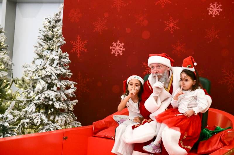 Sisters Hayal, left, and Umay Bayrak, aged 6 and 3, meet Santa at The Galleria mall. Khushnum Bhandari / The National

