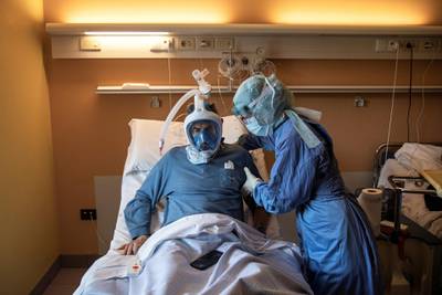 A nurse helps a patient using the Decathlon snorkeling face mask in the Covid-19 ward of the Maria Pia Hospital in Turin.  AFP