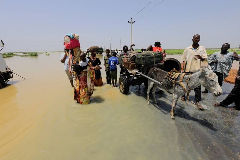 Residents load their bags onto a donkey-drawn cart, as they flee from the floods in Al Manaqil. 