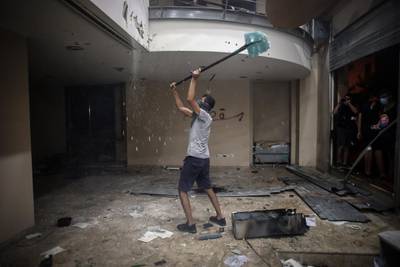 A protester strikes the ceiling inside the Lebanese Banks Association (ABL) headquarters during a demonstration. Bloomberg