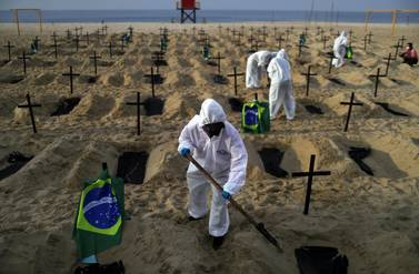 Activists dig graves on the beach to symbolise the dead from Covid-19 during a demonstration in Rio de Janeiro, Brazil. Reuters