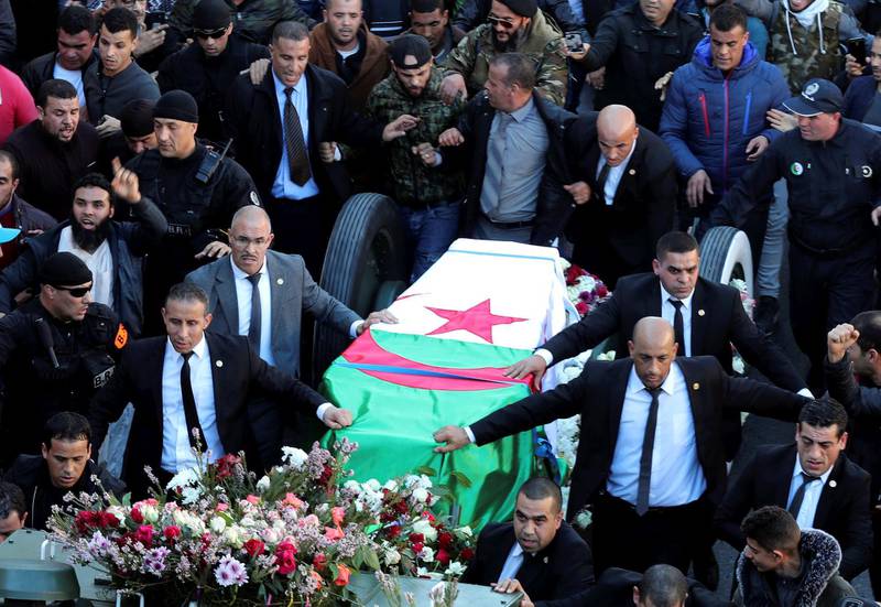 People walk next to the coffin of Lt Gen Ahmed Gaid Salah  in Algiers, Algeria. EPA