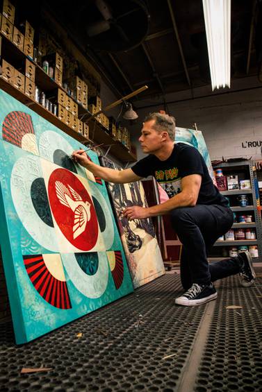 Shepard Fairey working on a painting of a peace dove. Courtesy Opera Gallery