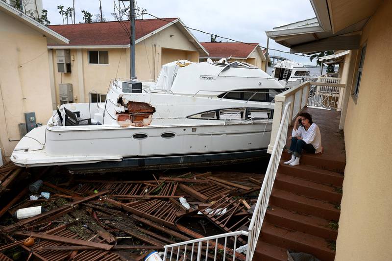 Florida resident Brenda Brennan next to a boat that washed up against her harbourside home in Fort Myers. AFP