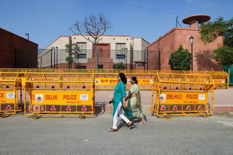 Women walk past India's new parliament in New Delhi. Reuters