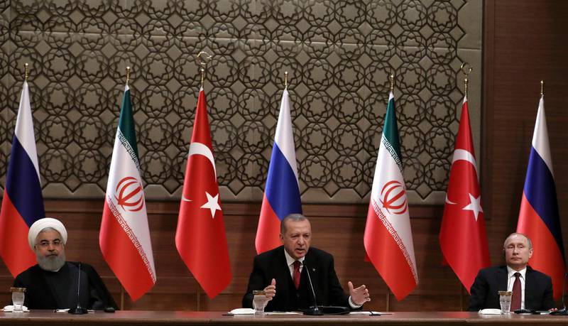 Iran's President Hassan Rouhani, left, Russia's President Vladimir Putin, right, and Turkey's President Recep Tayyip Erdogan speak during a joint press conference in Ankara, Turkey, Wednesday, April 4, 2018. The leaders of Russia, Turkey and Iran say they stand against "separatist" agendas that would undermine Syria's sovereignty and territorial integrity. In a joint statement released at the end of their summit meeting in Ankara, Putin, Rouhani and Erdogan said Wednesday they "rejected all attempts to create new realities on the ground under the pretext of combating terrorism." (AP Photo/Burhan Ozbilici)