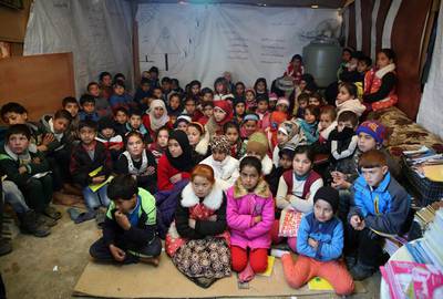 Syrian refugee children listen to their teacher inside a tent that has been turned into a makeshift school, in a Syrian refugee camp in the eastern town of Kab Elias, Lebanon, on January 27, 2016. Bilal Hussein, File/AP Photo