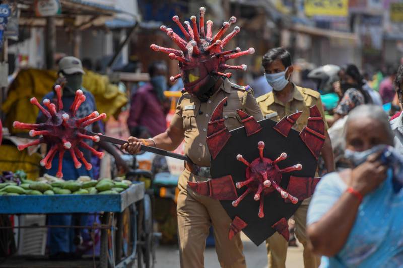 A policeman wearing a coronavirus-themed outfit composed of helmet, mace and shield, walks at a market to raise awareness about social distancing, during a government-imposed nationwide lockdown as a preventive measure against the COVID-19 coronavirus in Chennai, on April 2, 2020.  / AFP / Arun SANKAR                        
