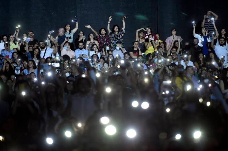 The audience use their mobile phones as a flashlight during the concert.