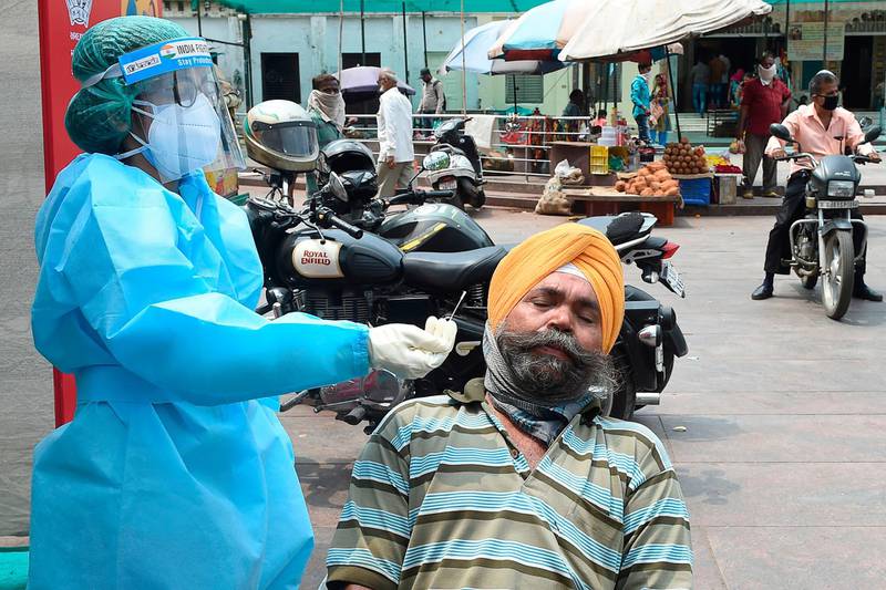 A health worker conducts a Covid-19 test on a man at a temporary screening centre in Ahmedabad. AFP