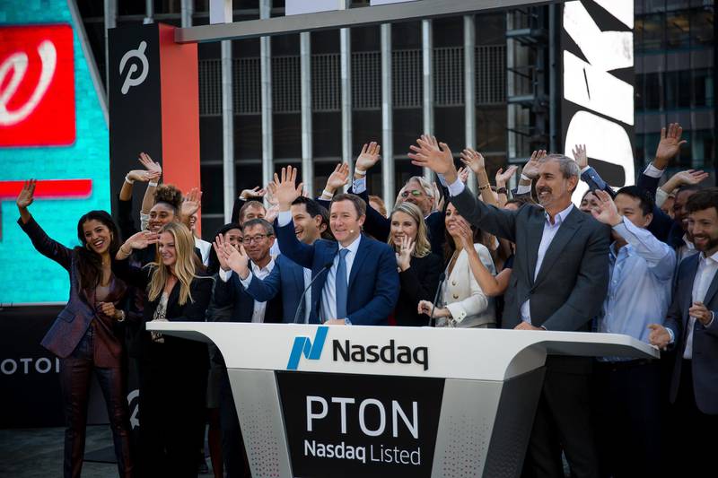 John Foley, co-founder and chief executive officer of Peloton Interactive Inc., center, rings the opening bell during the company's initial public offering (IPO) at the Nasdaq MarketSite in New York, U.S., on Thursday, Sept. 26, 2019. Peloton fell as much as 9.5% Thursday after raising $1.16 billion in its U.S. initial public offering, becoming the latest unprofitable startup to fail win over investors in its trading debut. Photographer: Michael Nagle/Bloomberg