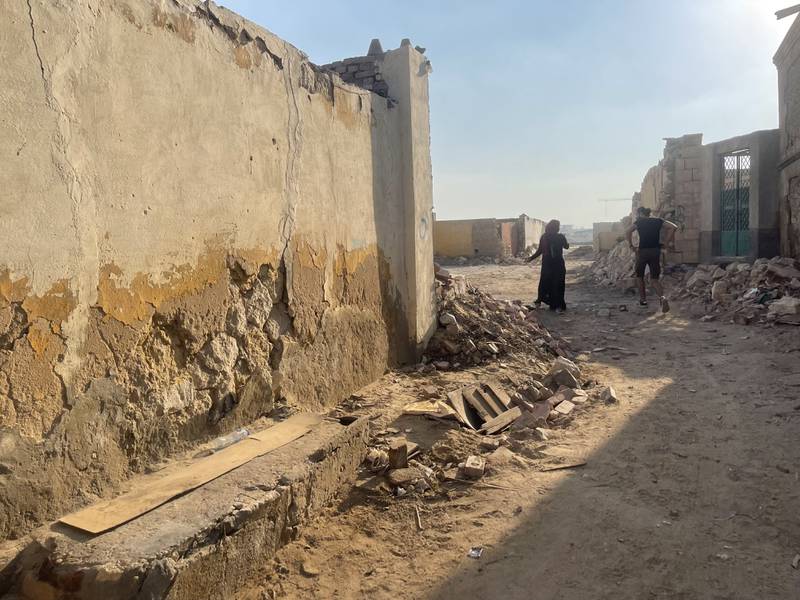 A man and woman walk through Cairo's City of the Dead where a government project to build roads and flyovers in the area has demolished many graves. Kamal Tabikha / The National