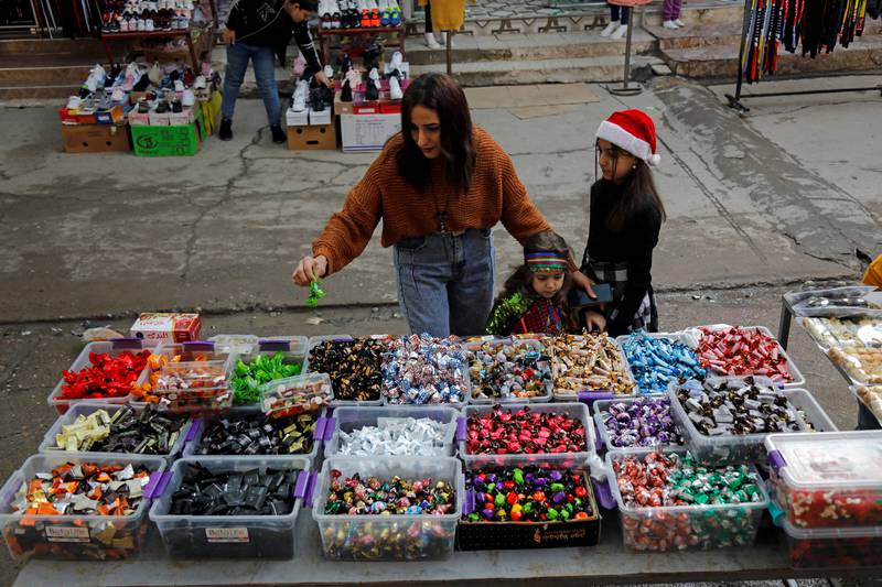 An Iraqi Christian family buys candies ahead of Christmas at a store in Al Hamdaniya. Reuters