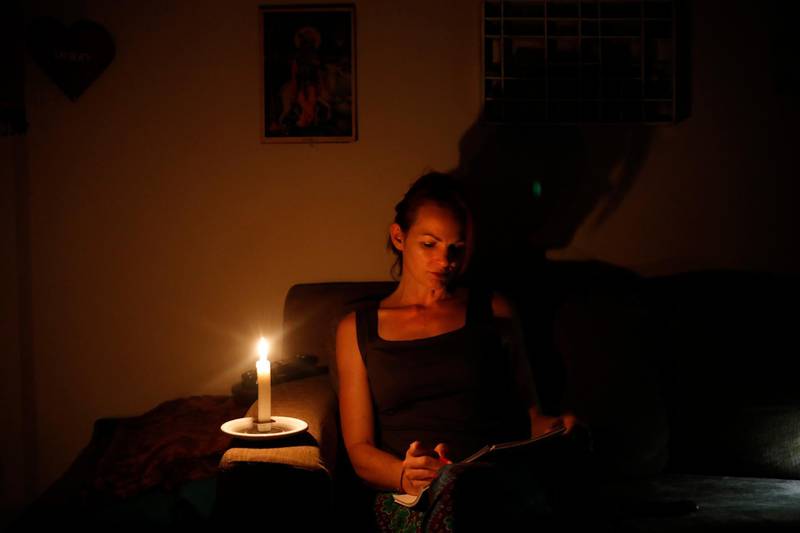 epa07446284 Hulda de Villiers, a graphic designer, has to work with the use of a candle after another power cut in her suburb of Johannesburg, South Africa, 18 March 2019. Load shedding, or the deliberate shut-down of parts of the electrical grid, intensified to a maximum scale on 16 March after the state power utility lost additional generation. The power cuts were raised to so-called Stage 4, removing 4,000 megawatts from the system, Eskom said in a statement on Saturday. It marked a third consecutive day of outages rotated throughout Africaâ€™s most industrialized nation.  EPA/KIM LUDBROOK
