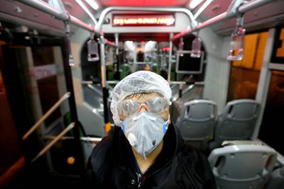 A Tehran Municipality worker cleans a bus to avoid the spread of the illness in Iran. AFP