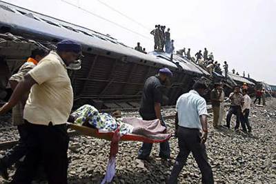 Rescue workers carry an injured passenger away from the overturned carriages of a train in the Jhargram area of West Bengal yesterday.