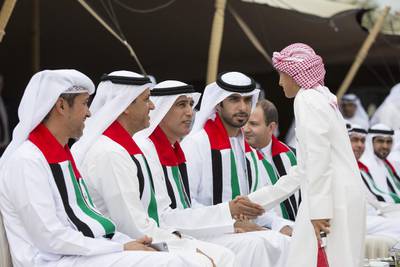 Jaber Al Suwaidi greets a young guest during National Day celebrations. Seen  Ali Al Romaithi, Saif Al Qubaisi, and Saeed Al Romaithi. Ryan Carter / Crown Prince Court - Abu Dhabi