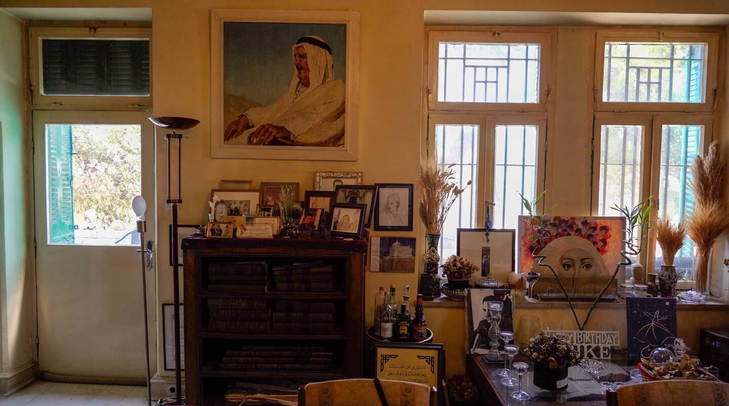 A portrait of Mahmoud Bisharat’s father, who built the house in which he now lives, hangs above a collection of family photos. Amy McConaghy / The National