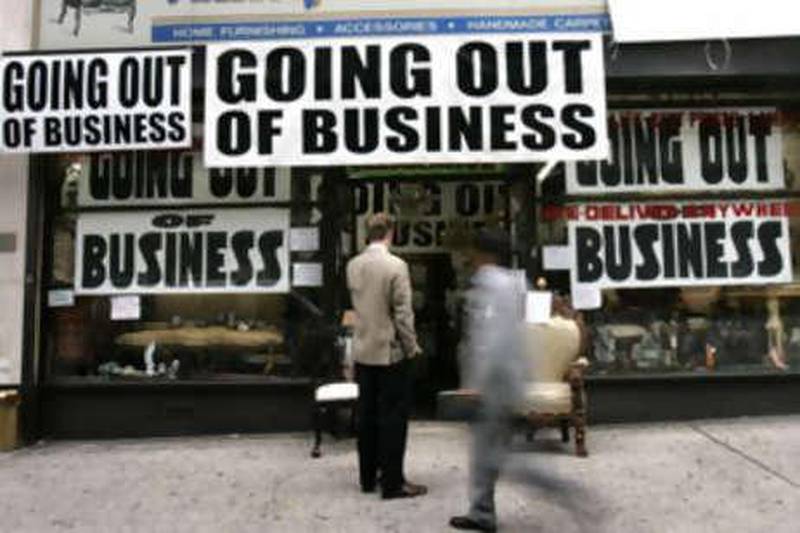 A man stands outside a store advertising that it is going out of business in New York on Oct 6 2008.