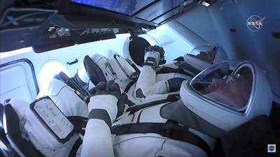 Nasa astronauts Bob Behnken, rear, and Doug Hurley are strapped in the SpaceX Crew Dragon capsule. Nasa