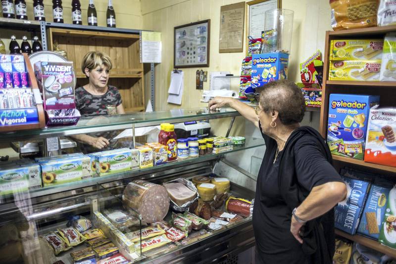 Mimma, a woman in her 50s who runs a grocery store in Riace, is a strong supporter of the model and has a banner outside of her shop that reads "I also support Riace".