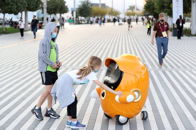 Visitors meet a robot at Expo on the first official Sunday of the weekend in the UAE in Dubai. Chris Whiteoak / The National