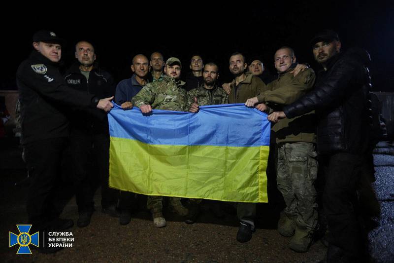 Some of the Ukrainian prisoners of war pose for a picture with their country's flag. Reuters