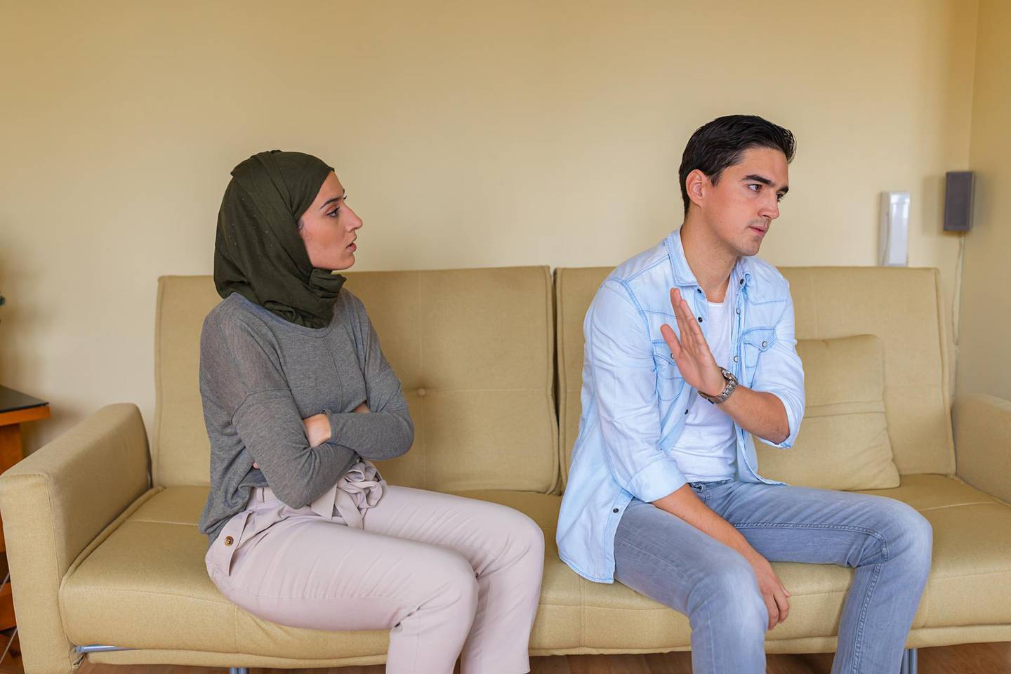 Young Muslim Woman is Having a Serious Discussion with her Boyfriend at Home While He is Ignoring her. Getty Images